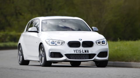 White BMW 1 Series driving along a country road